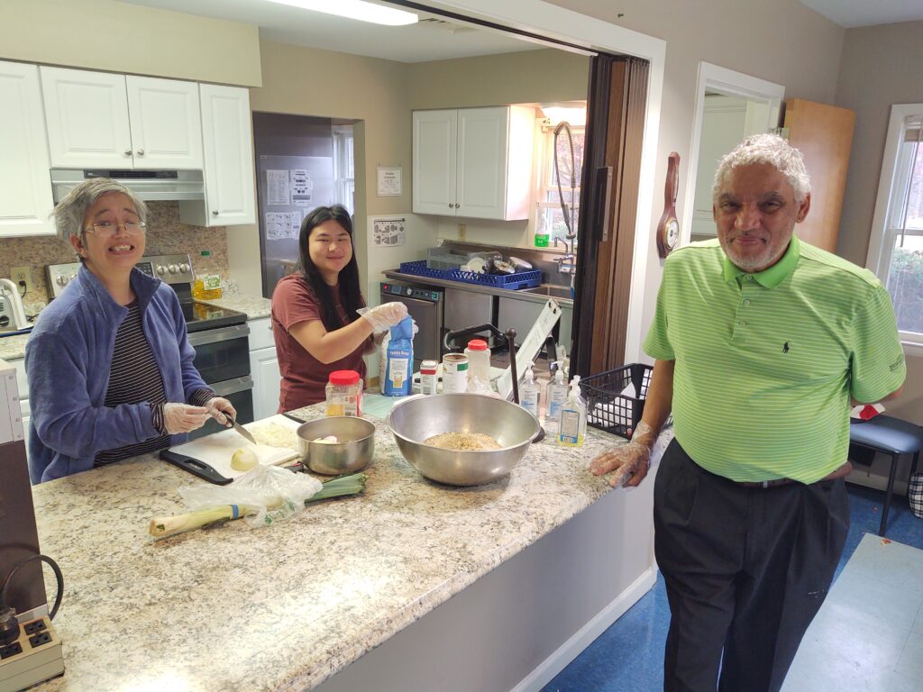 2 clubhouse members and a staff person cooking in the kitchen